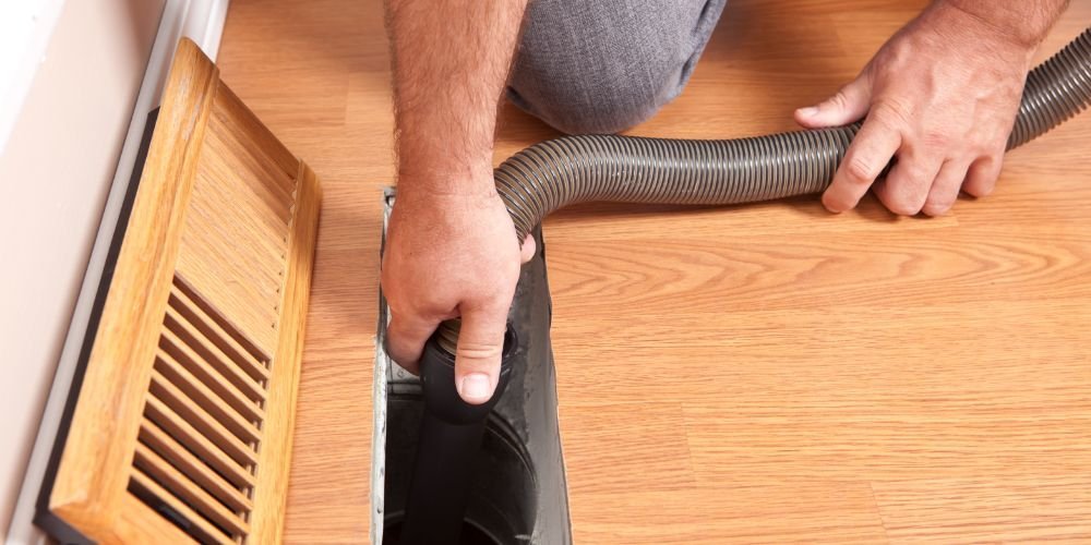 Professional man cleaning air duct